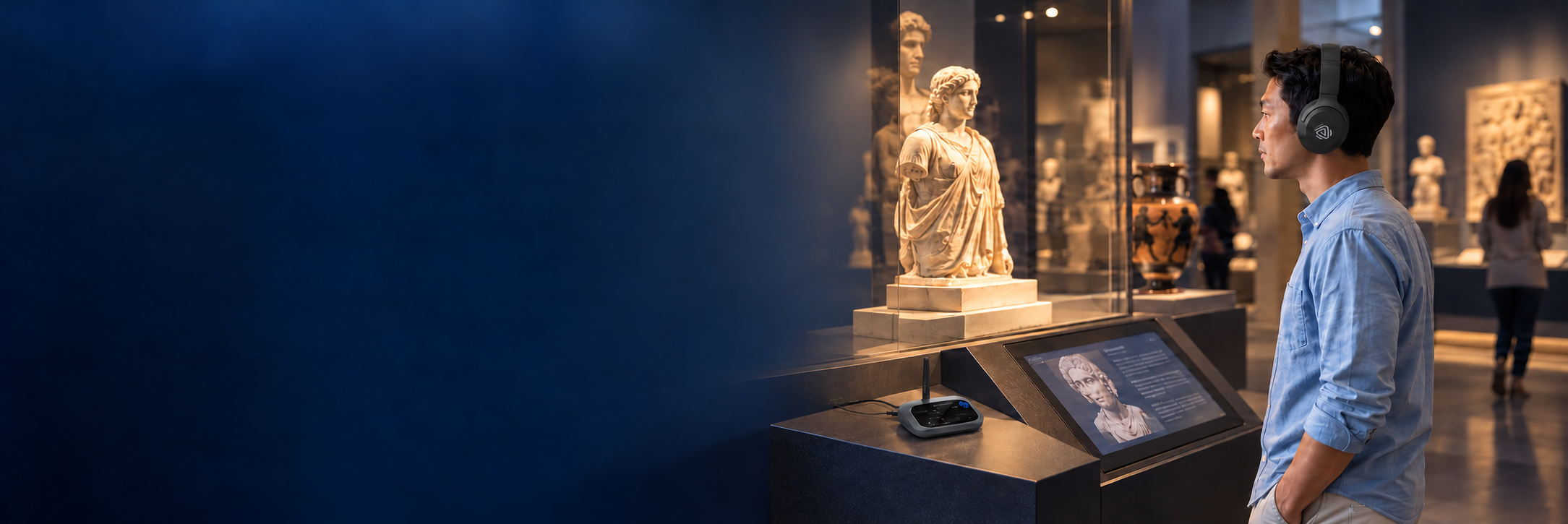 Museum visitor listening to an exhibit with Aria Aura T headphones and an Oasis Aura transmitter